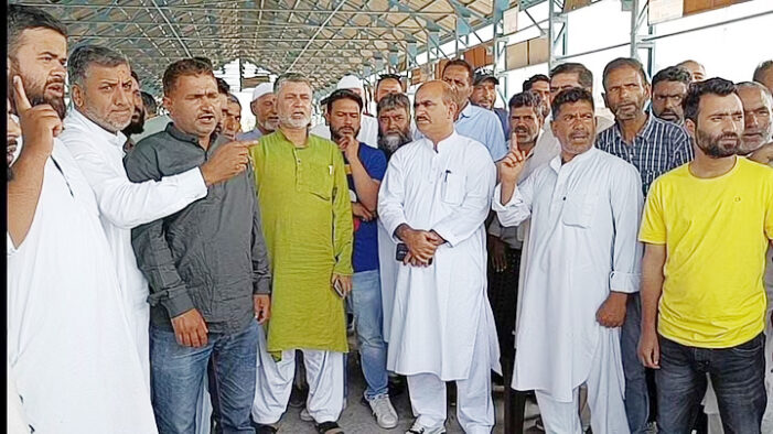 Fruit growers and dealers protest at Sopore fruit mandi over halting of trucks on NH-44